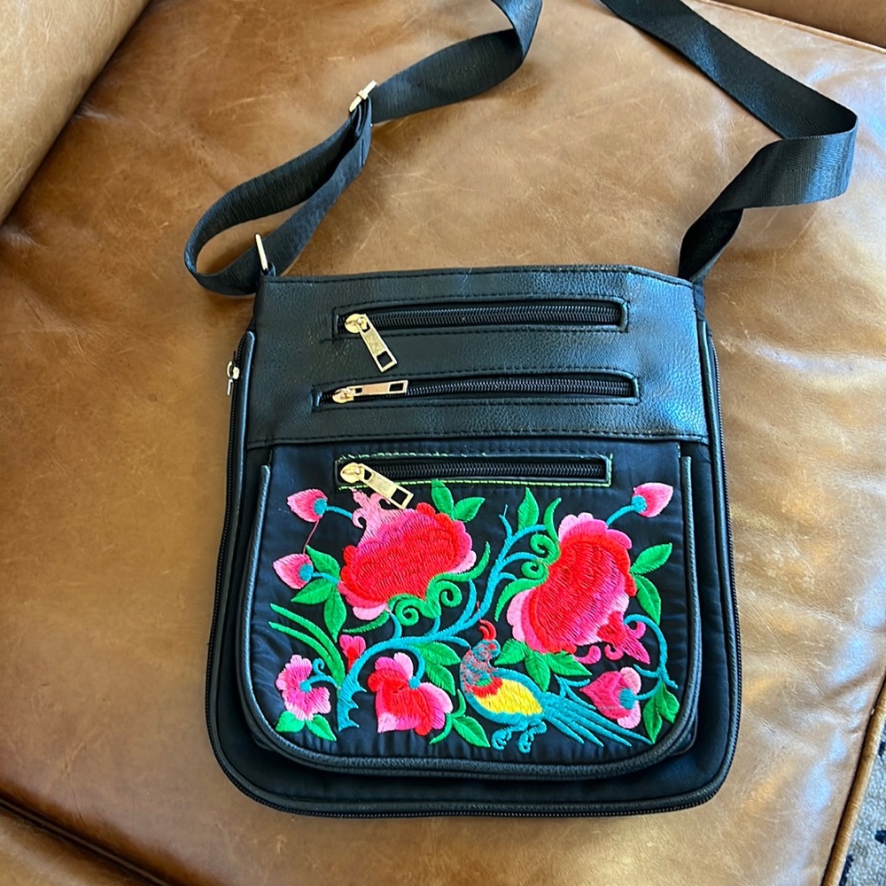 Embroidered cross body bag, does not appear to be leather.